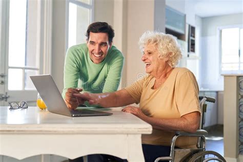 Man Helping Senior Woman On Laptop Computer With Video Call Stock Image