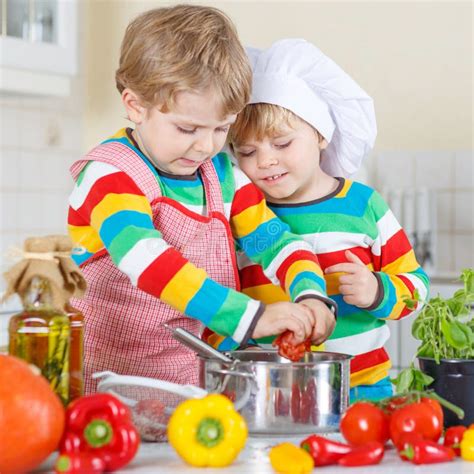 Two Cute Little Kid Boys Cooking Italian Soup And Meal With Fresh