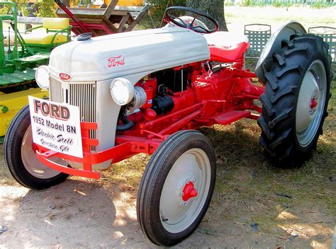 An Old Red And White Farmall Tractor Parked In Front Of Some Other