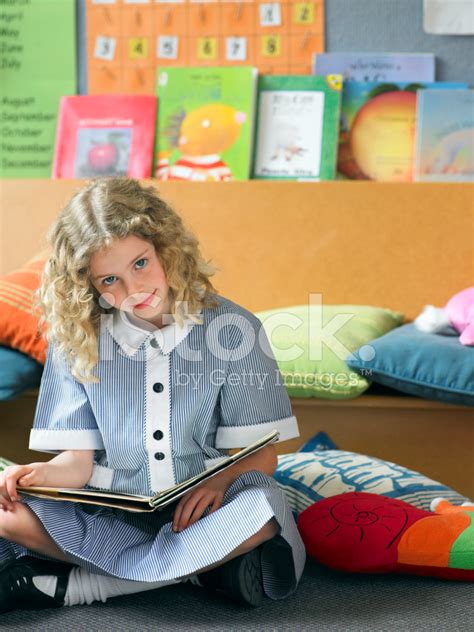 Girl Reading Book On Floor In Classroom Stock Photo Royalty Free
