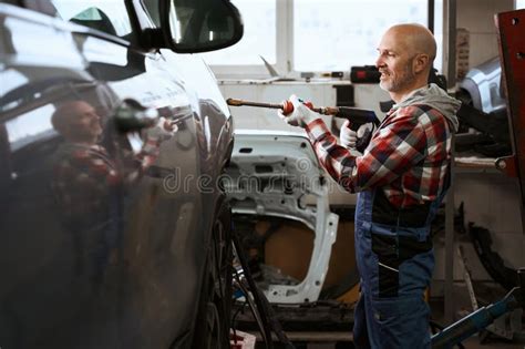 Auto Repairman Uses Spotter To Repair Car Stock Photo Image Of Modern