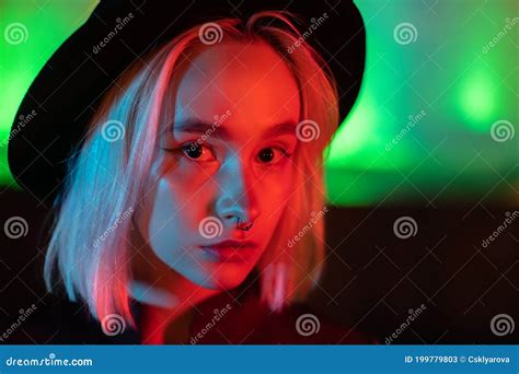 Hipster Woman With Blond Hairstyle Standing On Neon Glowing Background