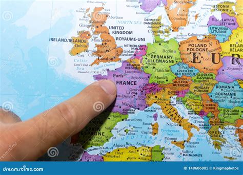 Finger Pointing To A Colorful Country Map Of Paris France In Europe