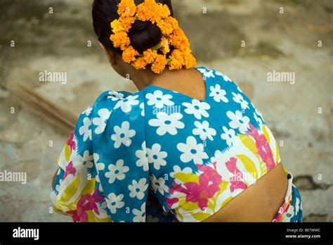A South Indian Maid Sweeps A Courtyard With Flowers In Her Hair Janakpuri New Delhi India