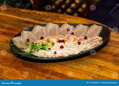 Meat Cuts On A White Plate On A Wooden Table In A Banquet Hall Stock