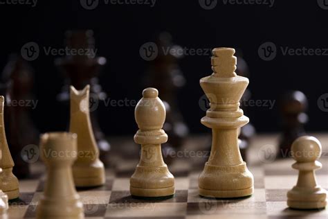 A Chess Board Asnd Pieces Against Black Background Stock Photo
