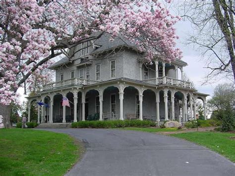 A Large House With Pink Flowers On The Trees
