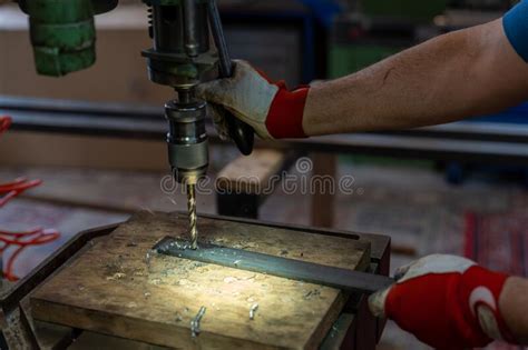 Metal Worker Drilling Holes In Metal With A Bench Drill Stock Photo