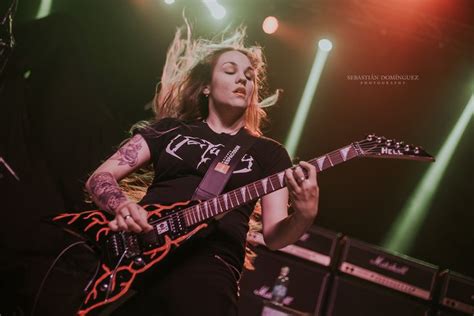 A Woman Playing An Electric Guitar On Stage