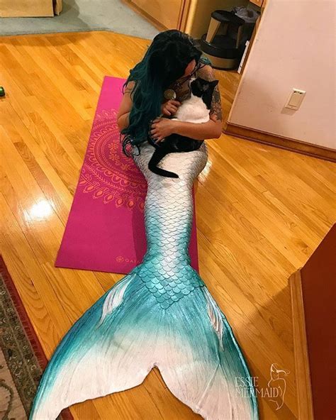 A Woman Holding A Cat In Her Arms While Standing On A Yoga Mat With A
