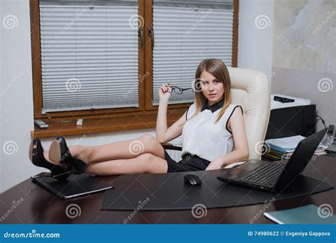 Business Woman Is Sitting With Her Feet On The Desk Stock Photo Image