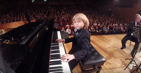 Ein Kleiner Junge Am Klavier Bringt Ein Orchester Von Erwachsenen In