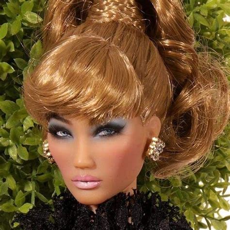 A Close Up Of A Barbie Doll With Blonde Hair And Blue Eyeliners On Her Face