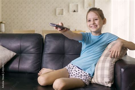 Cute Preteen Girl Watching Tv On Couch Using Remote Control Living