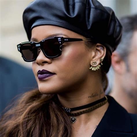 A Close Up Of A Person Wearing Sunglasses And A Hat With An Earring On