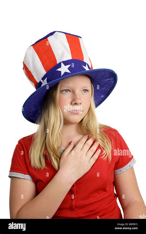 a pretty american girl in a stars and stripes hat solemnly saying the pledge of allegiance