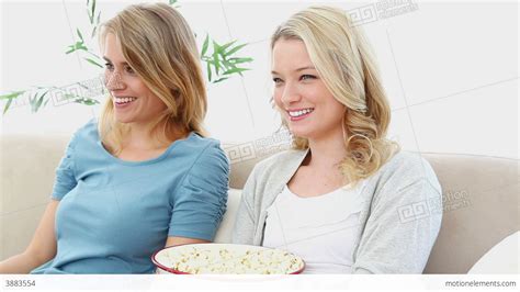 Two Blonde Women Eating Popcorn 動画素材 3883554