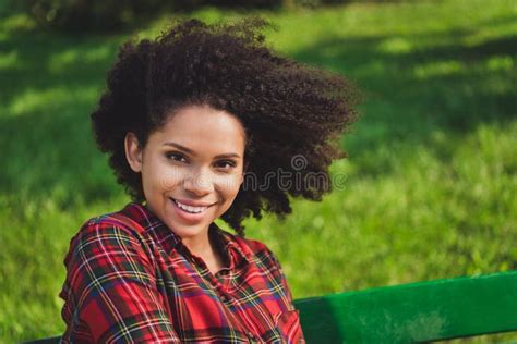 photo portrait woman sitting on bench in city park in summer windy weather wearing casual