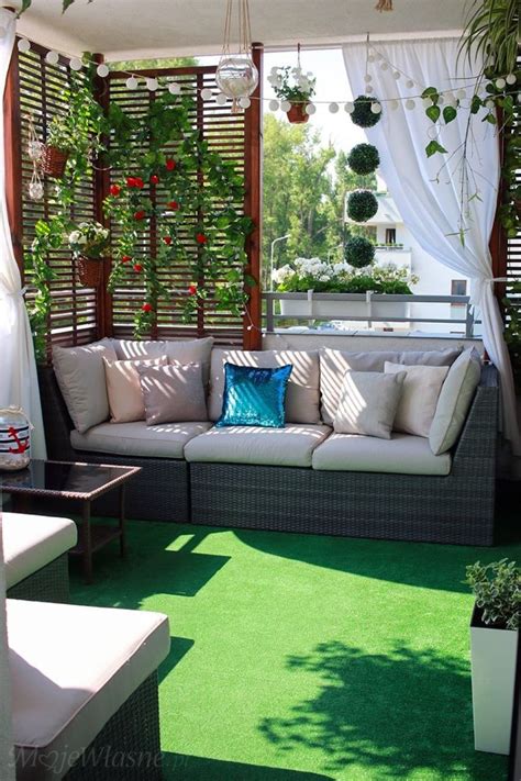 An Outdoor Living Area With Couches And Potted Plants