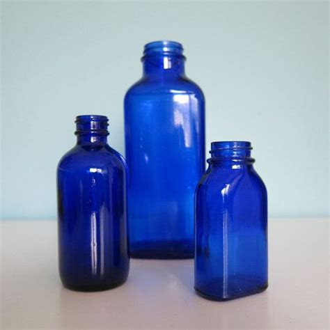 Three Blue Glass Bottles Sitting Next To Each Other