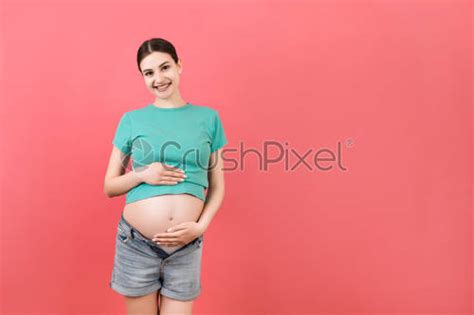 Naked Pregnant Womans Belly Wearing Opened Jeans At Colorful Background