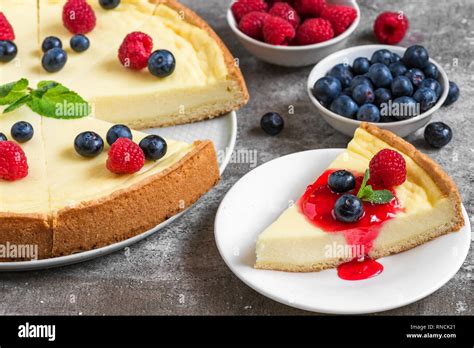 Classic Sliced New York Cheesecake With Fresh Berries And Jam On Stone