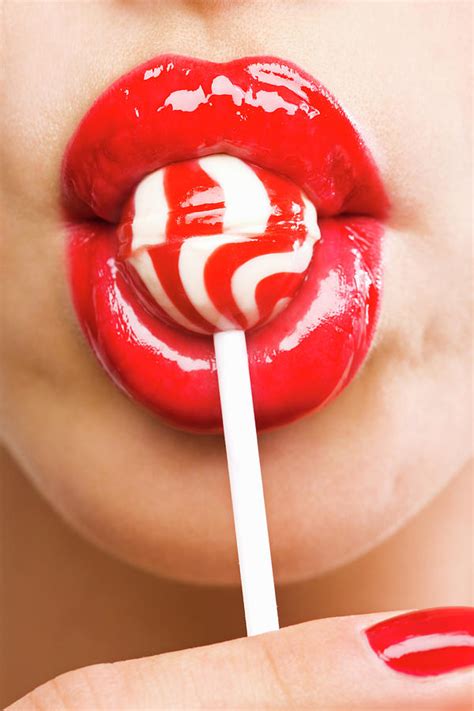 close up of a womans mouth with lollipop by pando hall