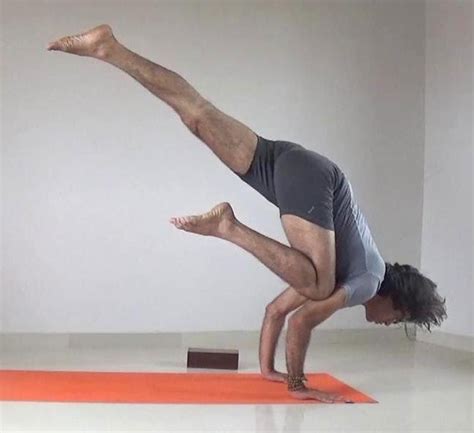 Woman practicing yoga, doing crane exercise. One Legged Crow Yoga Pose - YogaWalls
