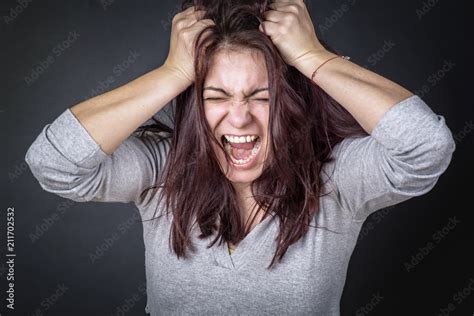 Frustrated angry woman screaming and pulling her hair babe woman angry фотография Stock