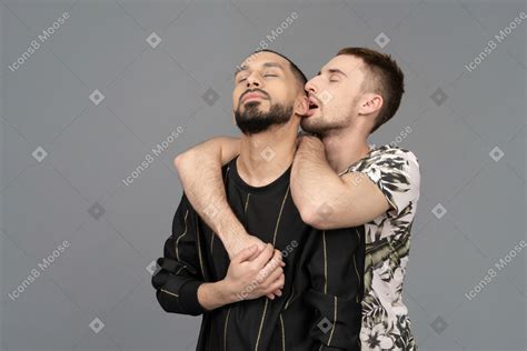 Фото Молодой кавказский мужчина обнимает другого мужчину со спины