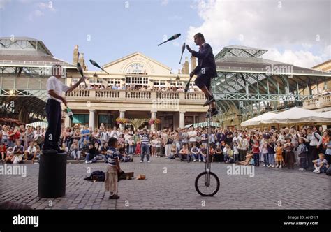 Street Performers Juggling On Unicycle In Covent Garden London Stock