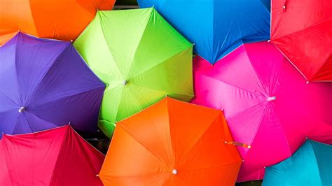 Many Different Colored Umbrellas Are Stacked Together