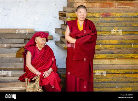 Two Buddhist Nuns In Traditional Robes Attend Religious Festival At