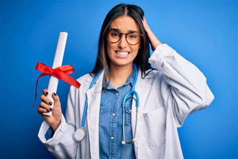 Young Beautiful Brunette Doctor Woman Wearing Glasses And Coat Holding Diploma Degree Stressed