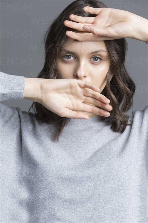Portrait Of Brunette Young Woman Hands Over Her Face Stock Photo