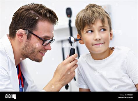 Male Doctor Examining Boys Ear With An Otoscope Stock Photo Alamy