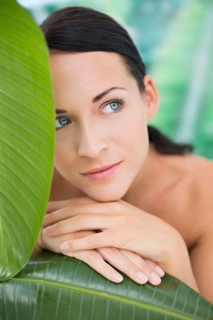 premium photo beautiful nude brunette posing with green leaves