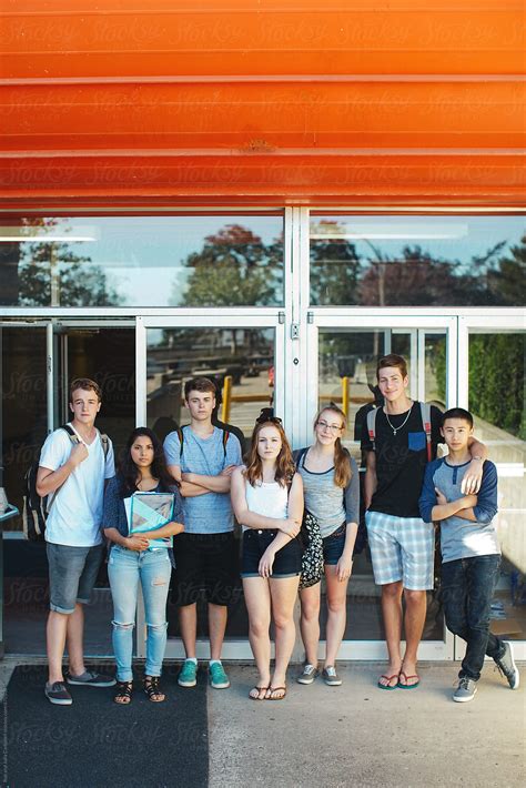 Group Of Serious High School Teens Standing In Front Of School On
