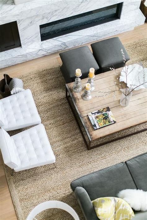 Natural variations in the color and veining of marble make each piece subtly unique. A reclaimed wood box frame coffee table is placed on a ...