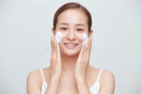 Happy Asian Woman Wash Her Face With Soap Foam Over White Background