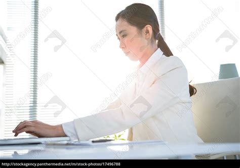 Smiling Businesswoman Typing On Her Laptop Lizenzfreies Foto