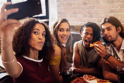 Diverse Group Of Friends Enjoying Meal And Taking Selfie Stock Image