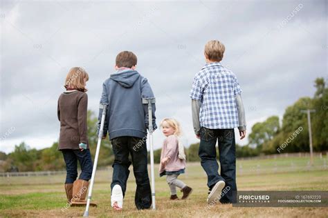 Niño en muletas con otros niños unidad Longitud completa Stock Photo