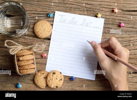 Woman Hand Write To Do List On Wooden Table With Chocolate Chip Cookie