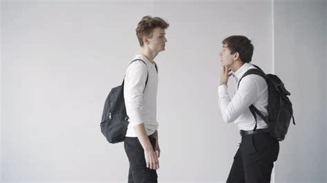 Side View Of Angry Teenagers Arguing And Fighting In School Corridor
