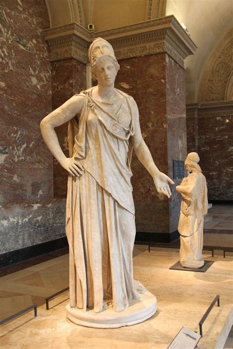 A Statue Of A Woman Standing In Front Of A Wall With Marble Walls And