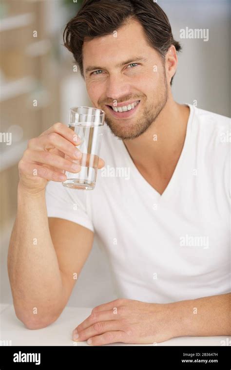 Happy Man Drinking Water In Kitchen Stock Photo Alamy