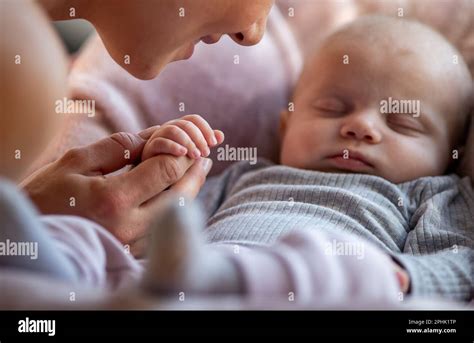 Close Up Of Cute Baby Hand Holding Mothers Finger While Sleeping