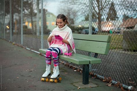Preteen Girl Wearing Roller Skates Using Smartphone While Seated On A