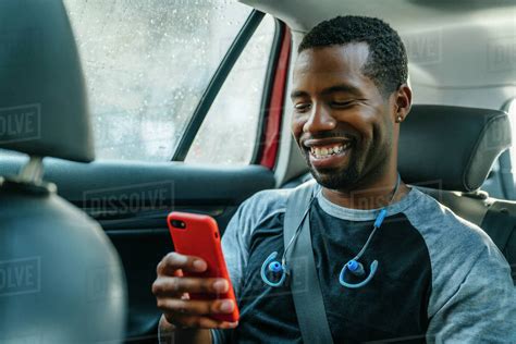 Smiling Black Man Texting On Cell Phone In Car Stock Photo Dissolve